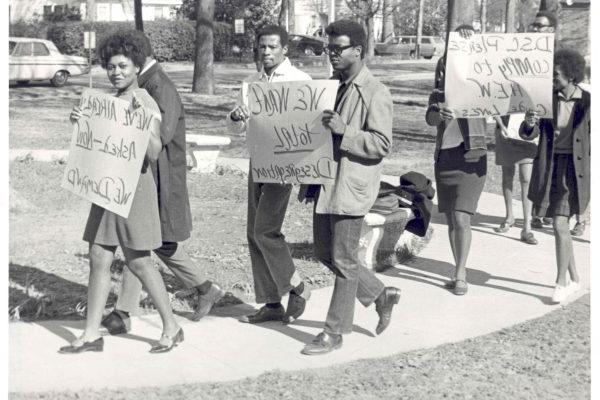 Students marching with signs on Delta State campus.